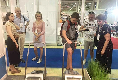 Buyers trying QUEN shoe cover dispenser at an international exhibition